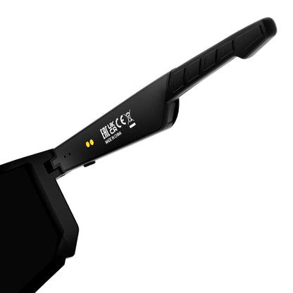 Close-up of a black protective smart glass arm or strap with molded grip texture, white printed symbols and text, and two small yellow dots on a plain white background.