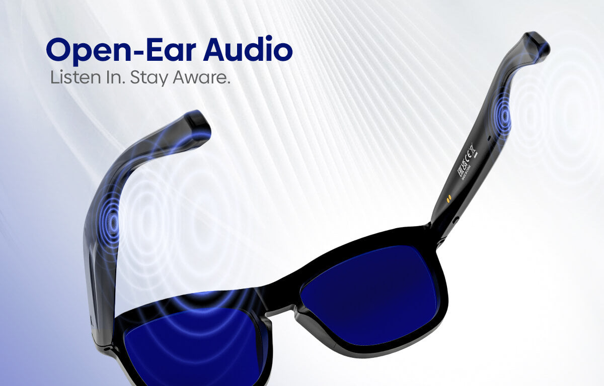 Open-Ear Audio sunglasses with black frames and dark blue lenses, featuring blue sound wave graphics and the text 'Open-Ear Audio Listen In. Stay Aware.