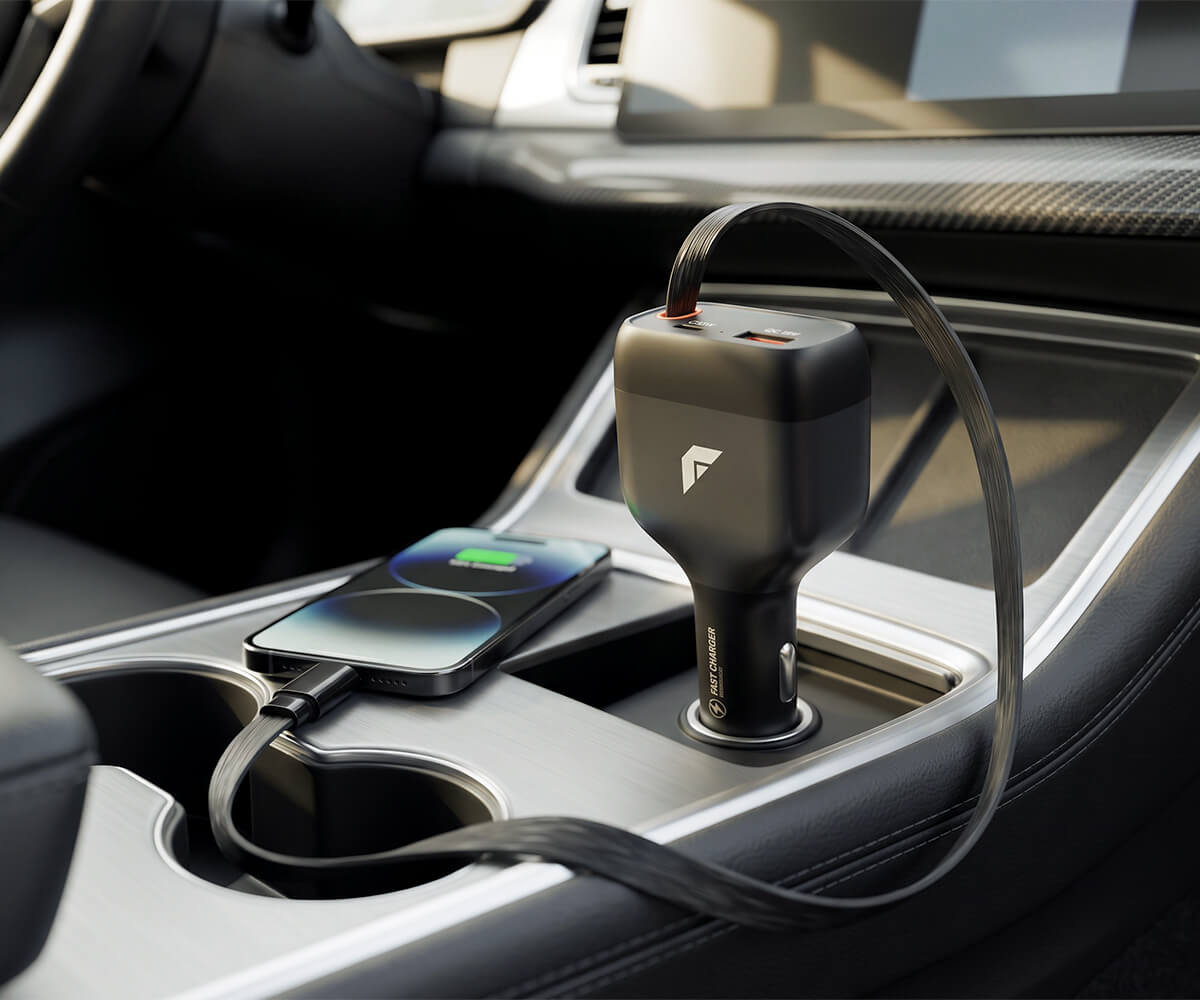 A black car charger plugged into a vehicle's center console USB port, with a smartphone charging in the cup holder beside it.