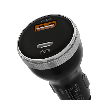 A close-up of a black car charger plug showing two charging ports: a larger USB-C port labeled 'QC 18W' with an orange accent, and a smaller USB-A port labeled 'PD 30W'. The charger has a textured silver metallic ring around the port opening and a black body with white text and technical specifications.