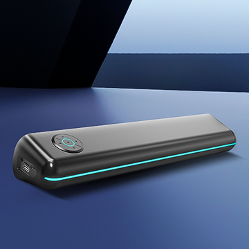 A black wireless speaker with a blue light accent lying on a flat surface.