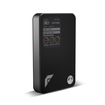 A black rectangular portable power bank with rounded corners, a digital status display on the front, three circular buttons, and a silver power button, shown on a white background.